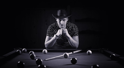 A man with a beard plays a big billiard. Party in a 12-foot pool