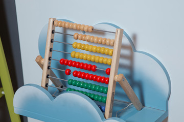 Traditional counts abacus with colorful wooden beads on gray background. Toy abacus to learn...