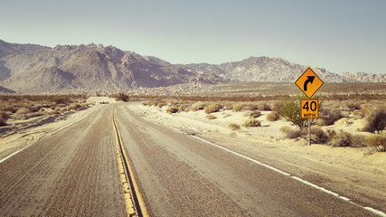Desert highway with speed limit sign, panoramic retro stylized picture, travel concept, USA.