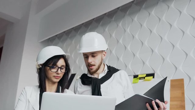 Close-up of the faces of two architects working on a laptop