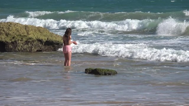 Young girl splashing in the waves