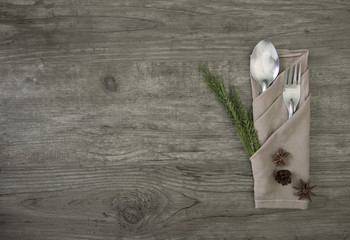 spoon and  fork with napkin setting on wood table top view.