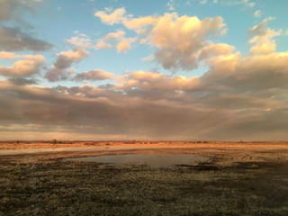 sunset in clouds with sunrays over road to horizon