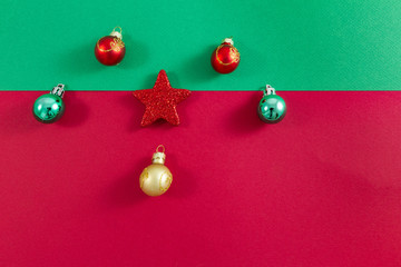 Fototapeta na wymiar Christmas star and balls on green and red off-centre