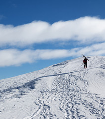 Naklejka na ściany i meble Skier with skis go up to top of snowy mountain