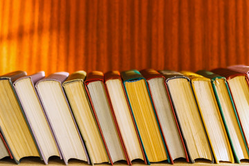 on the table a series of books tilted to the left.