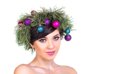 A beautiful woman in a wreath of Christmas tree branches and New Year's decoration on white background, isolate.