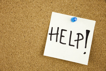 help - word handwritten on a stack of sticky notes posted on cork bulletin board