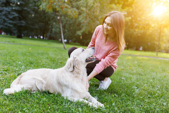 Photo of brunette with dog lying on lawn . Sunlight effect