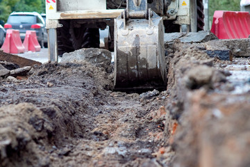 Fototapeta na wymiar excavator removes road asphalt