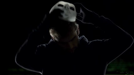 Anonymous scary hacker taking off mask, IT criminal disclosure, confession