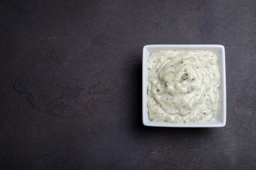 Traditional french sauce remoulade in a white bowl on a black da