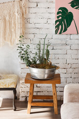 Modern loft interior with flowers in big metal pot. White brick wall on background