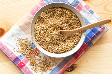 sesame on wood spoon and in metal silver bowl