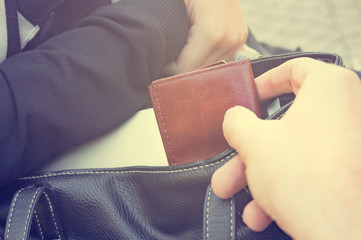 Thief stealing the wallet from the bag, close-up. Instagram filter