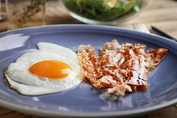 Plate with fried egg and bacon, closeup
