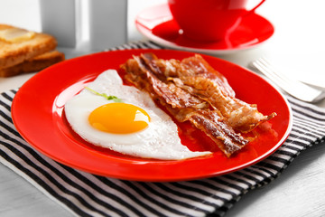 Plate with fried egg and bacon, closeup