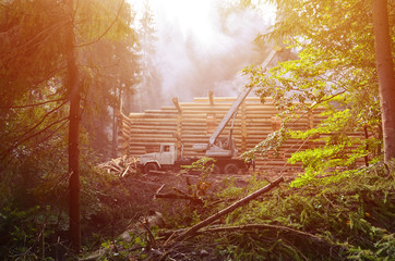 The process of building a wooden house from wooden beams of cylindrical shape. Crane in working...