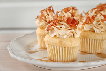 Tasty cupcakes with bacon on plate, close up