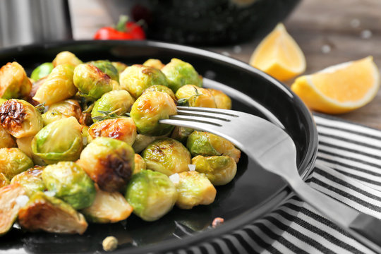Plate with roasted brussel sprouts on table, closeup