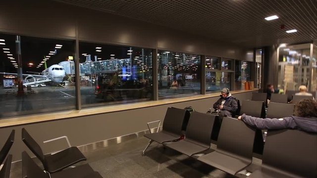 Man with a smartphone waiting for the announcement of the boarding on aircraft