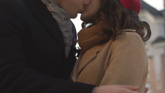 First kiss of a pretty couple, young male and female dating, autumn in big city