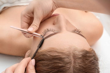Young woman having eyebrow correction procedure in beauty salon