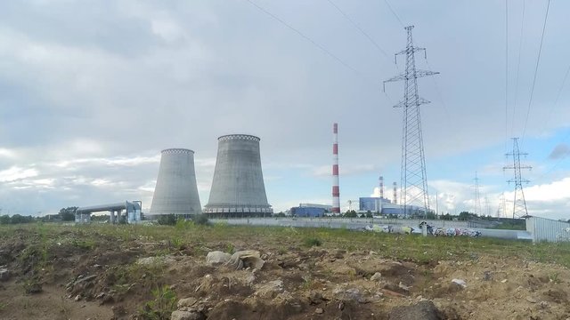 Factory pipes, power towers and white clouds in summer timelapse