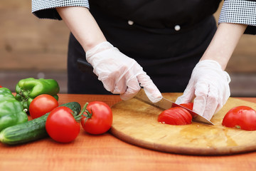 The cook cuts fresh farm vegetables