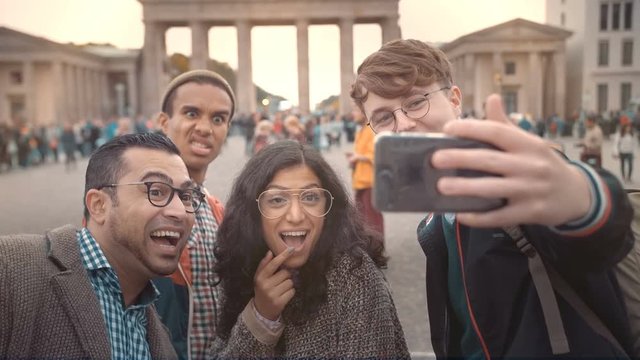 Happy faces of friends unny Friends of different nationalities make selfies in memory of the Brandenburg Gate in Berlin