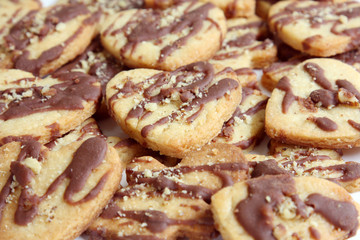 Obraz na płótnie Canvas background heart shape butter cookies with chocolate and nuts, texture, pattern 