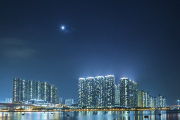 Fototapeta na wymiar High rise residential building in Hong Kong Harbor at night