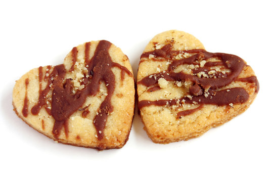 isolated couple of heart shape cookies with chocolate and nuts with copy space, simbol of love