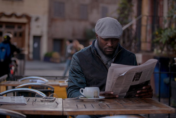 Reading newspaper at outdoor cafe