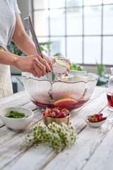 Woman hands pouring sangria into glasses party drinks