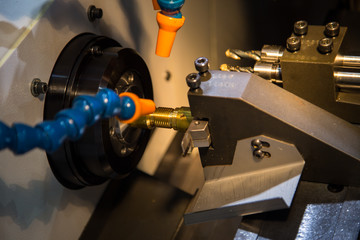 Fototapeta na wymiar High precision CNC Lathing machine cutting brass workpiece. Industrial metalwork machinery