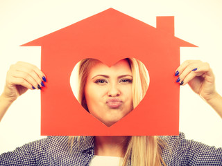 Happy woman holding red paper house