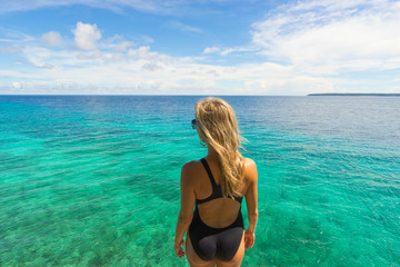 Obraz premium Woman in black swimwear. Sea and sky on background.