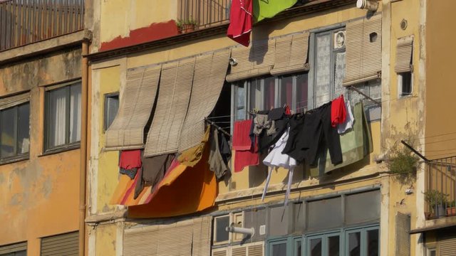 Clothes hanging on a colourful facade in the wind