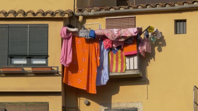 Clothes hanging on a colourful facade in the wind