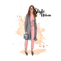 Urban style. Fashionable bow. Hand drawn sketch. Stylish young woman in a pantsuit and coat. A hand holding a bag. Vector illustration.