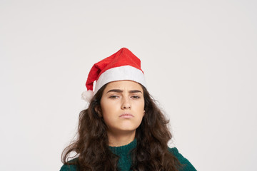 beautiful woman with brown hair in a Christmas hat, emotion, bright background, free space for copy, new year, christmas, holiday