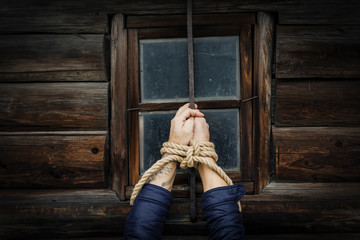 Male hands tied with a rope.