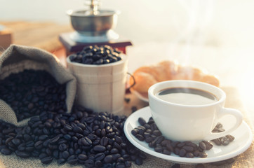 Coffee cup and coffee beans on wooden table