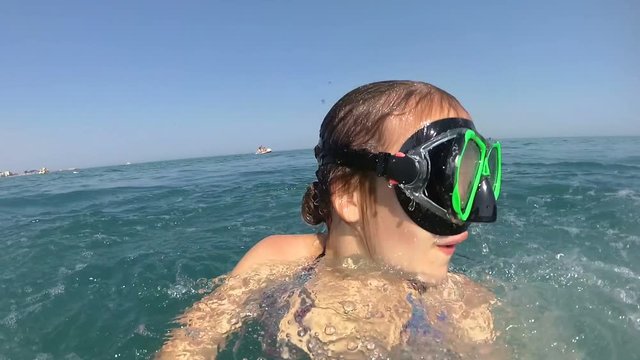 girl on pedal boat pulls off the hill into the sea, view from water