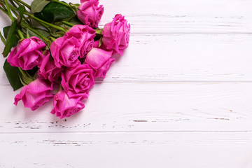 Bunch of pink  roses  flowers on white wooden background.