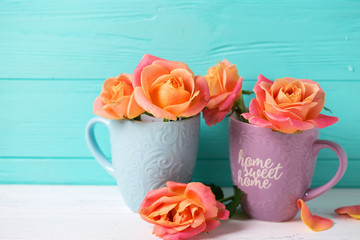 Fresh orange roses in blue cups