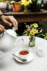 Woman pouring tea in a cup
