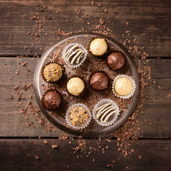 A set of chocolates from various chocolate on a dark wooden background. View from above.