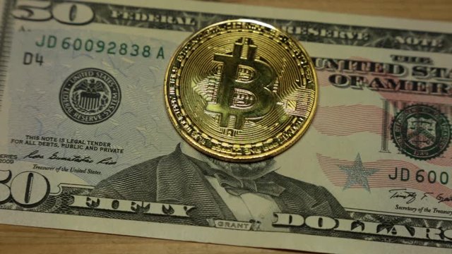 50 American Dollars and coin bitcoin.